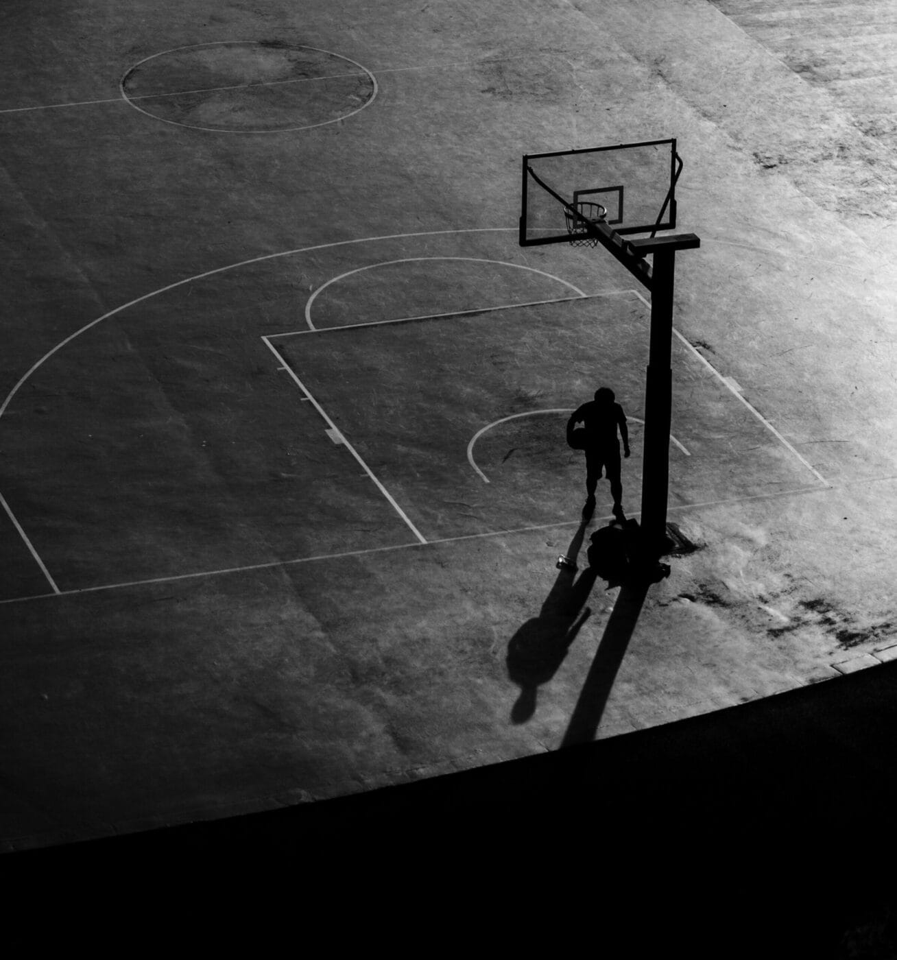 qi-xna-bball court unsplash 021724 2 - Ball to Life person on dark basketball court