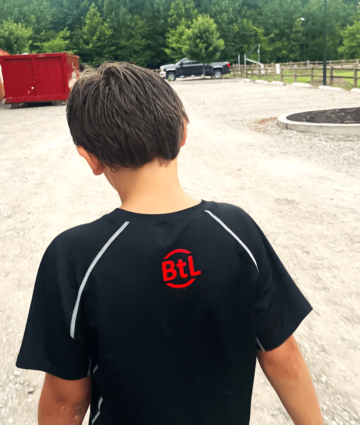 Jackson 2 071324 - Leading With Purpose boy in ball to life shirt walking to football practice