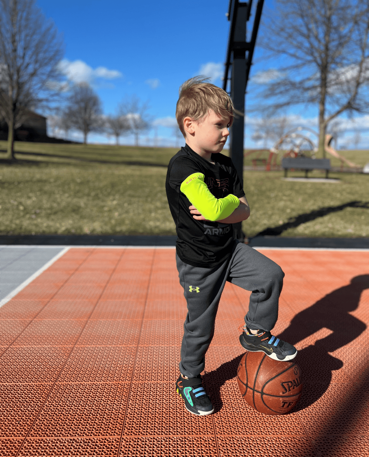 Self confidence young boy wearing ball to life arm sleeve with basketball