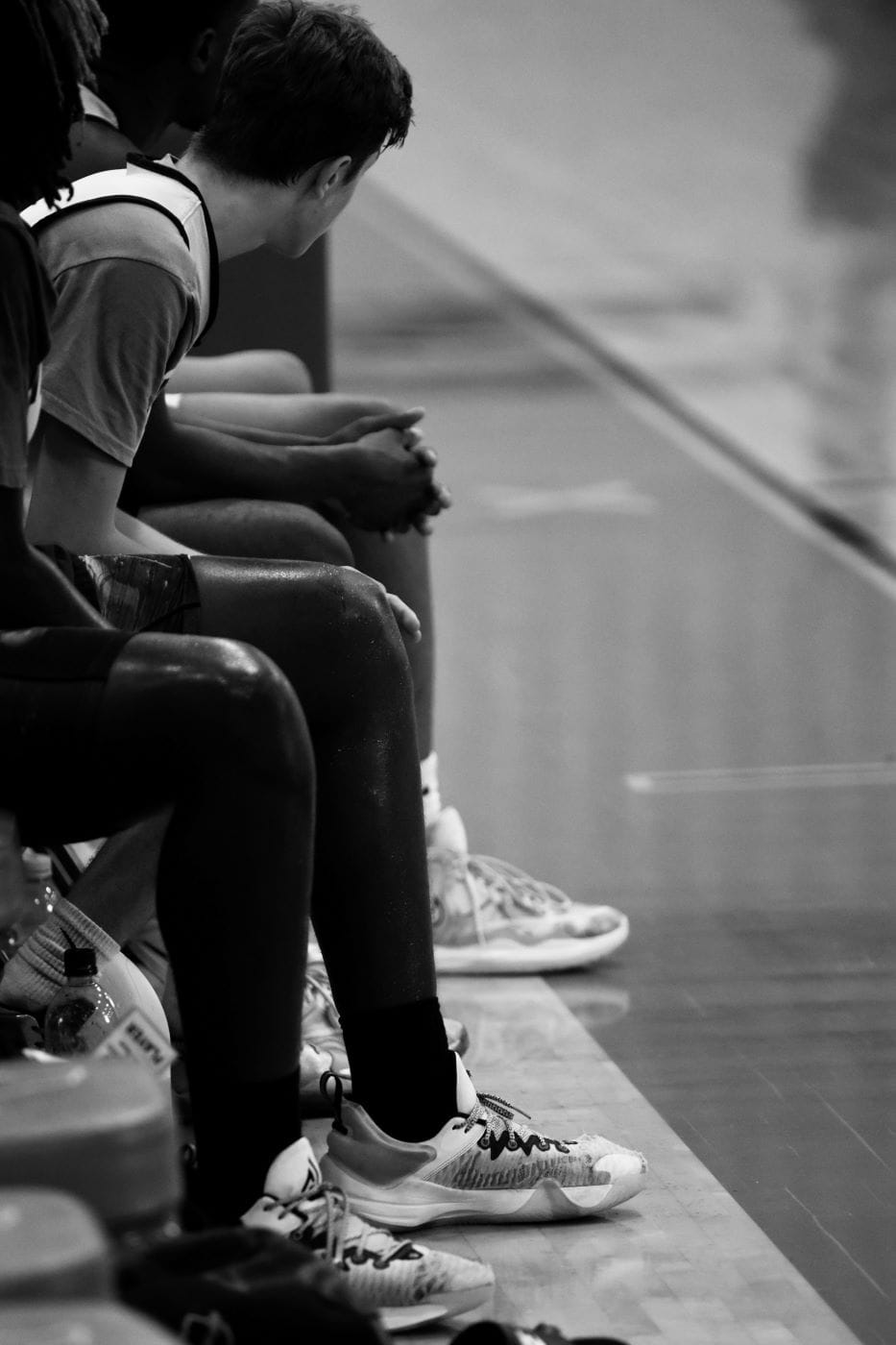 boys sitting on bench on basketball court