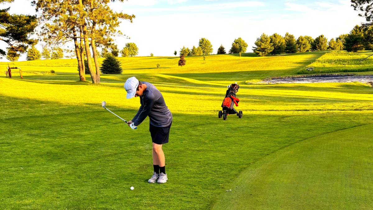 Teenage boy hitting golf chip shot