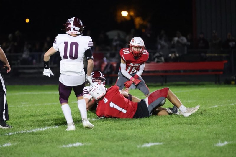football player making tackle while teammate celebrates