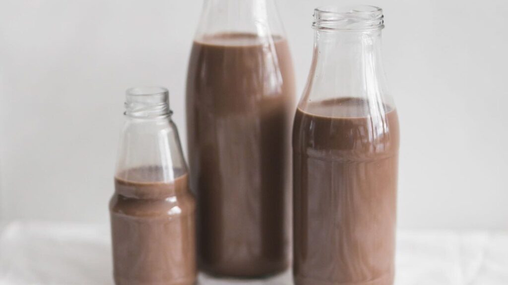 milk-chocolate-bottles-tablecloth-against-white-backdrop - Ball to Life Sports Nutrition for athletic performance chocolate milk bottles on tablecloth
