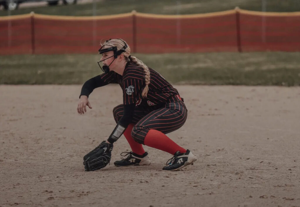 softball player Quinn Hoeper fielding a ball beyond the play player spotlight